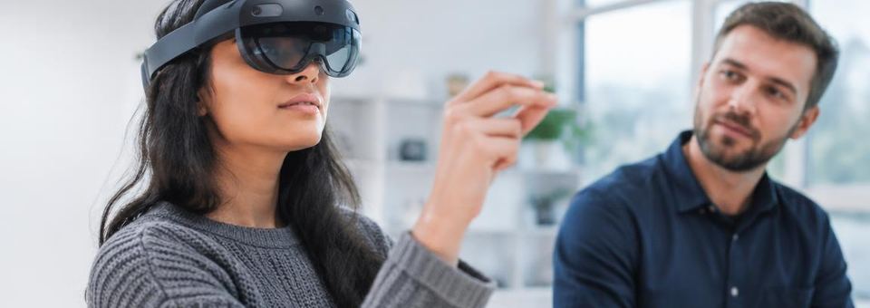 Person mit Mixed-Reality-Brille in einem hellen Studio