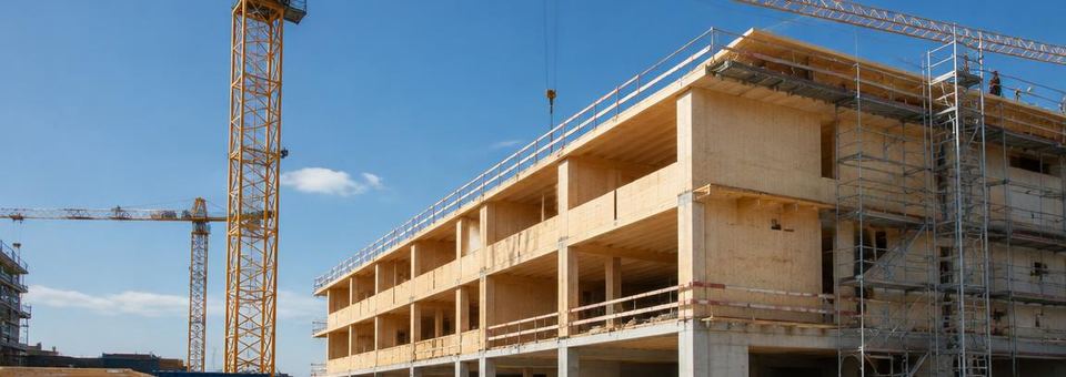 Baustelle mit Kran und Holzbau