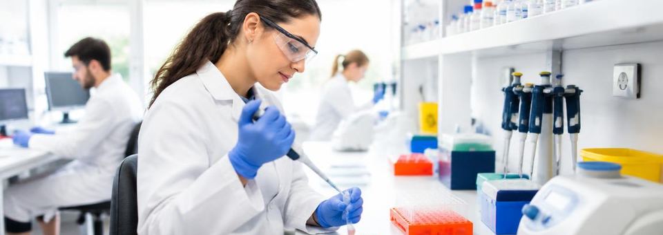 Wissenschaftlerin mit Pipette in einem hellen biomedizinischen Labor