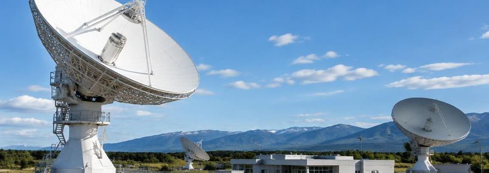 Satellitenantennen einer Bodenstation unter blauem Himmel